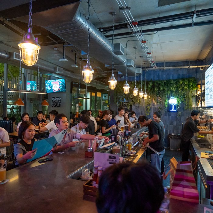 Guests along the bar at a busy BrewDog Bangkok night